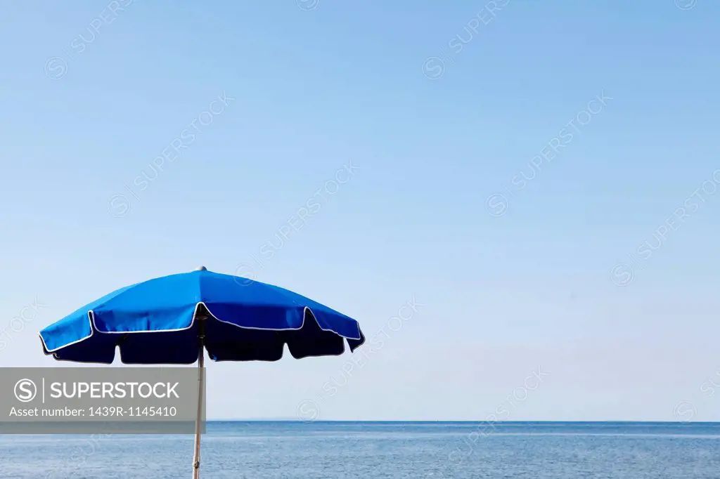 Blue parasol against the sea