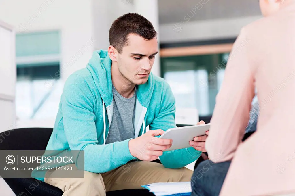 Man concentrating on digital tablet