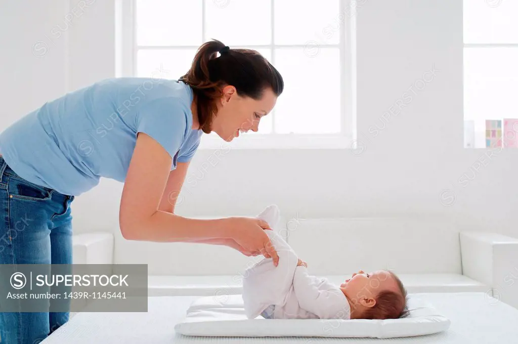 Mother with baby girl on changing mat