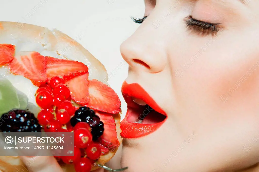 Young woman eating fresh fruit