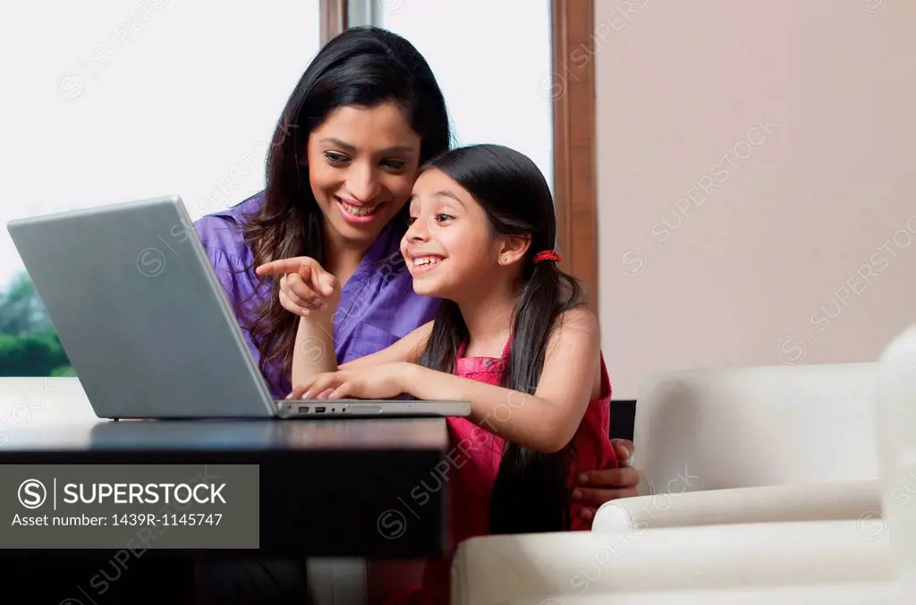 Mother and daughter having fun on a laptop