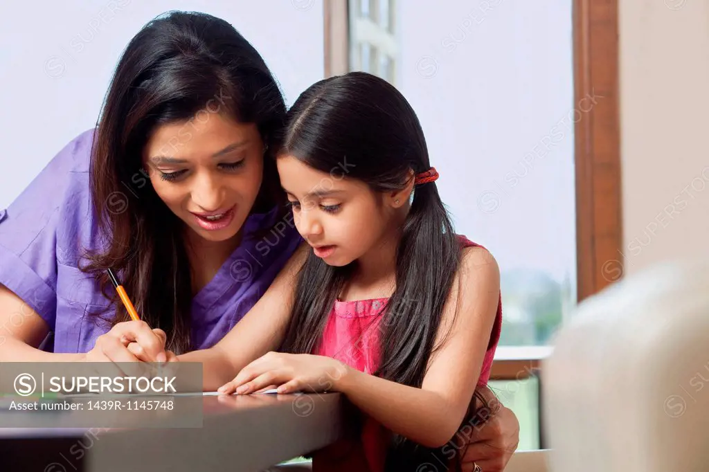 Mother teaching her daughter to write