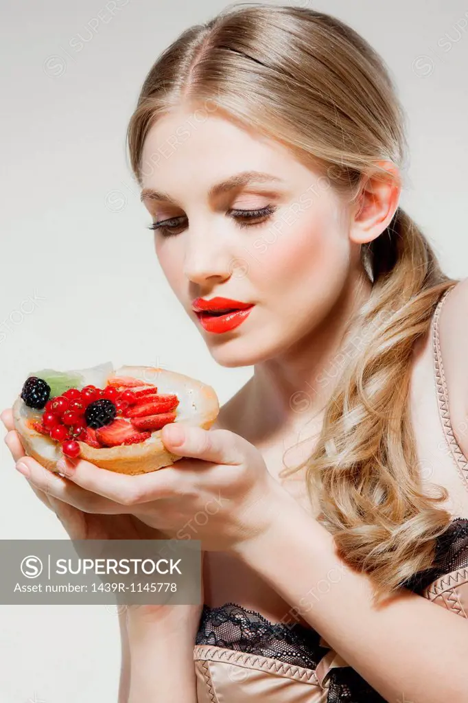 Young woman holding fresh fruit tart