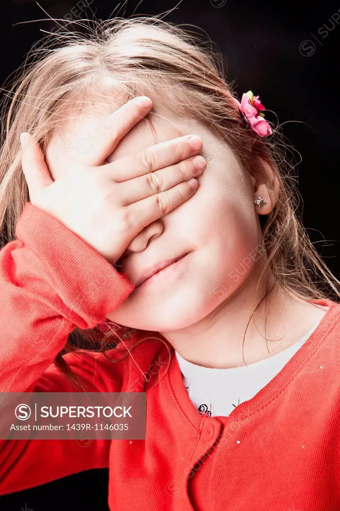 Little girl covering her eyes