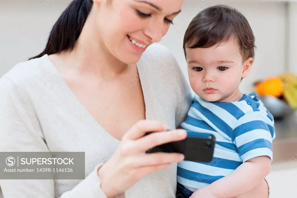 Mother and baby son looking at smartphone