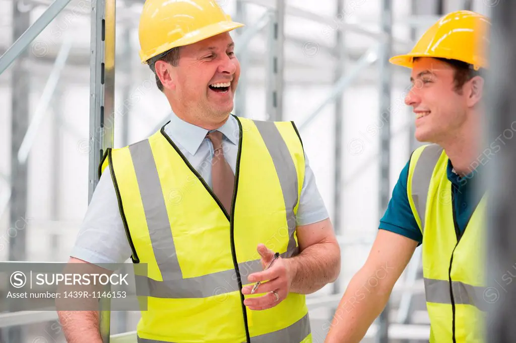 Two men laughing in warehouse