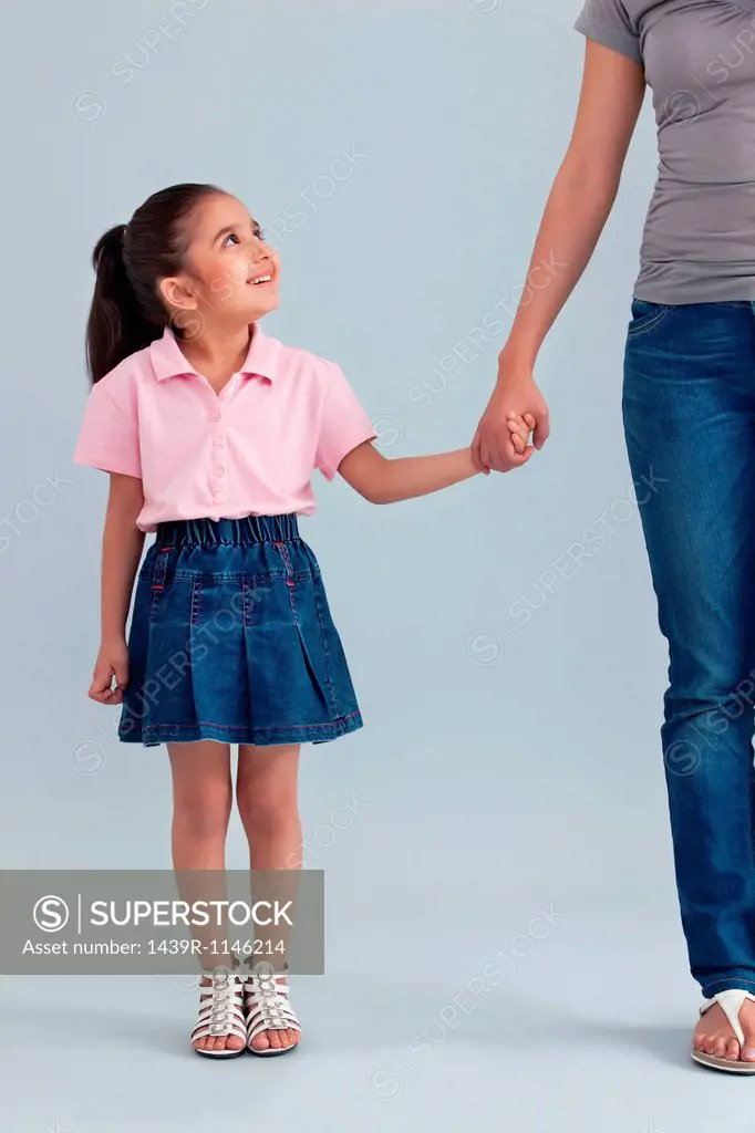 Young girl holding her mothers hand