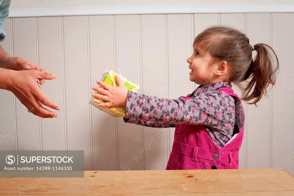 Little girl giving a gift to adult