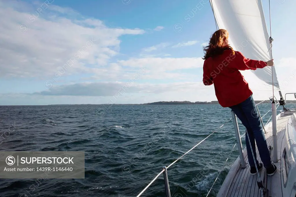 Woman sailing on yacht, rear view