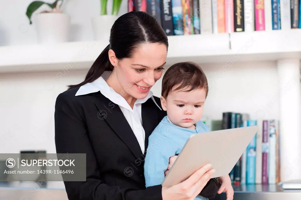 Businesswoman mother and baby looking at digital tablet
