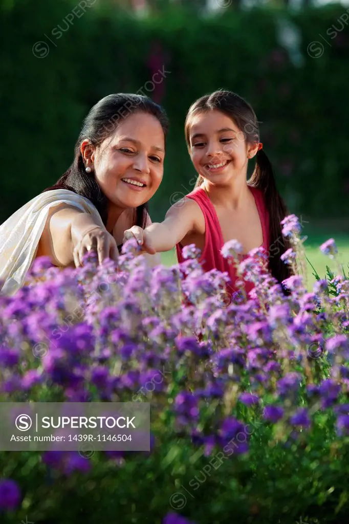 Girl and her grandmother looking at flowers