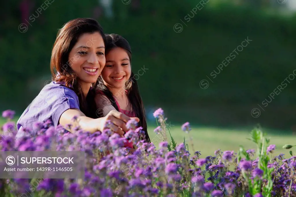 Mother and daughter plucking flowers