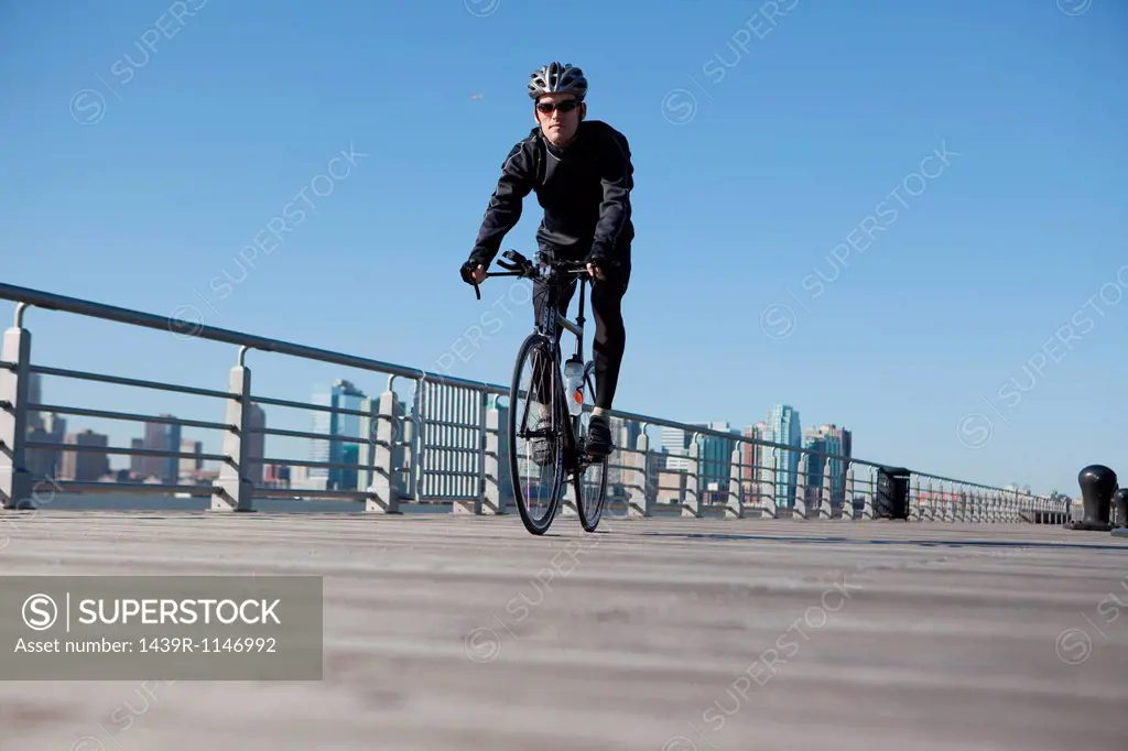 Man cycling over bridge