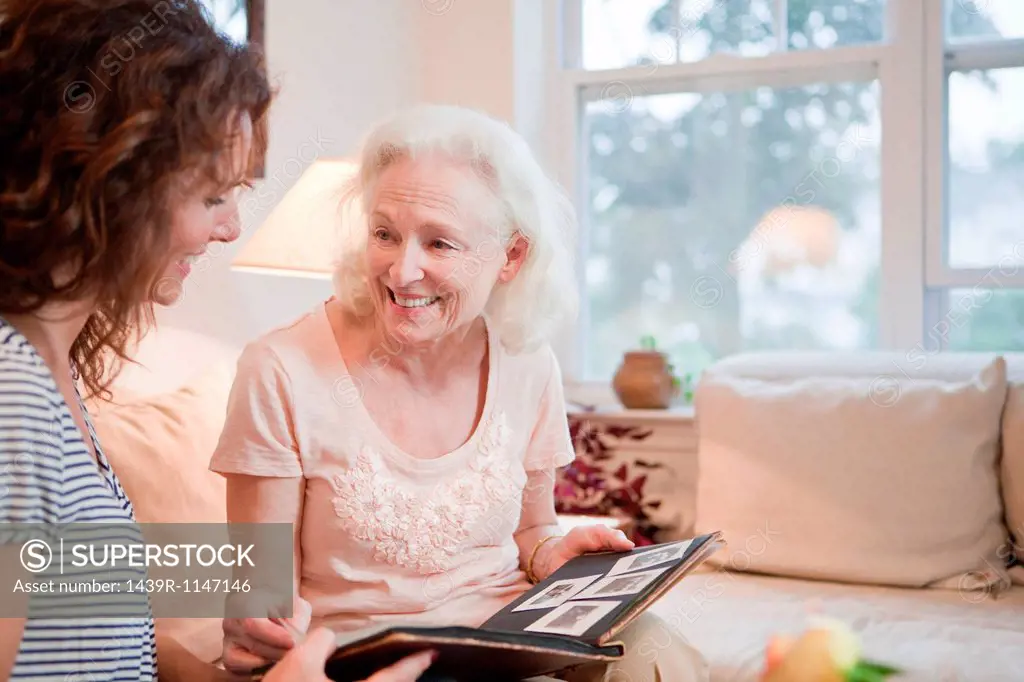 Senior woman and daughter looking through photo album