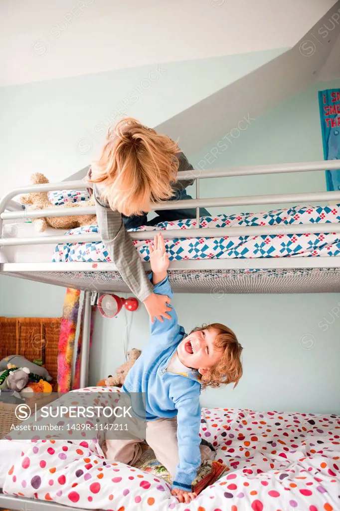 Young boys playfighting on their bunk bed