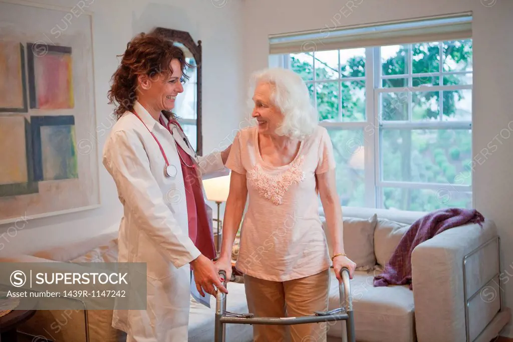 Doctor supporting senior woman on walking frame