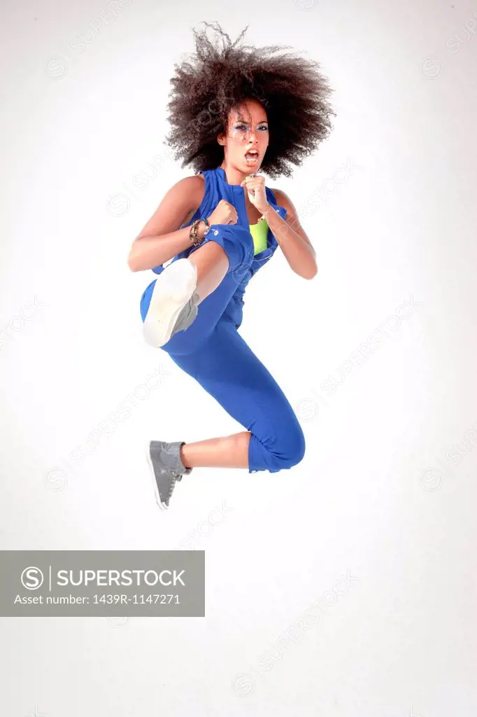 Young woman kicking in mid air