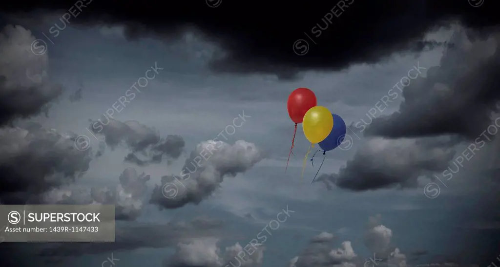 Balloons floating through dark sky
