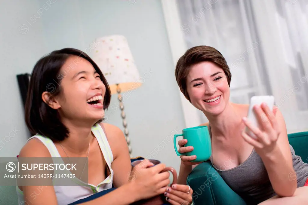 Young women looking at smartphone and laughing