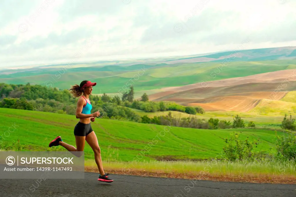 Young woman running in landscape of Palouse Hills, Washington, USA