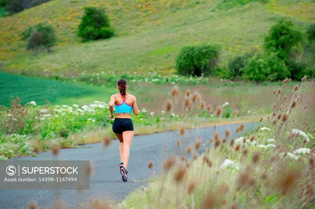 Young woman running in rural setting