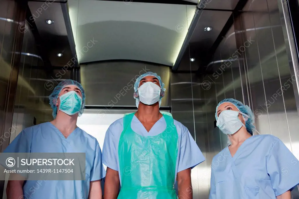 Three surgeons in hospital elevator