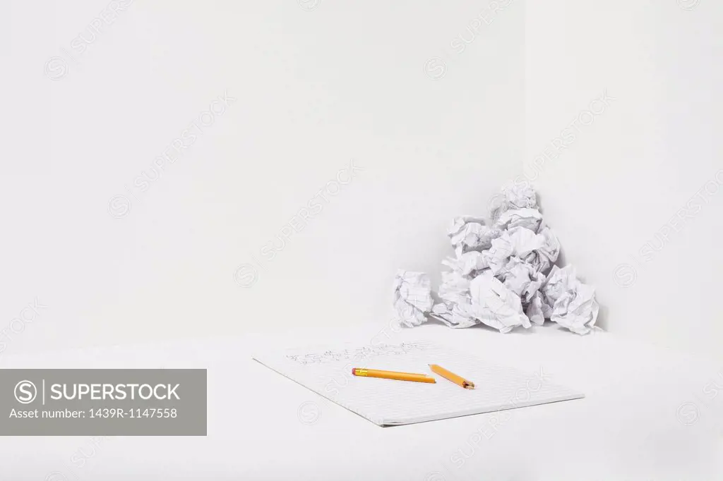 Broken pencil, notebook and crumpled paper