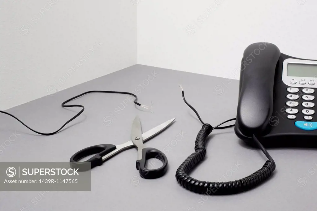 Landline phone, cut cable and scissors