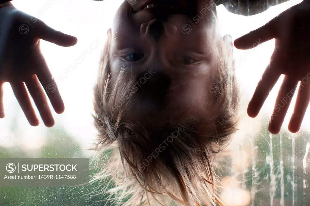 Boy looking through window, upside down