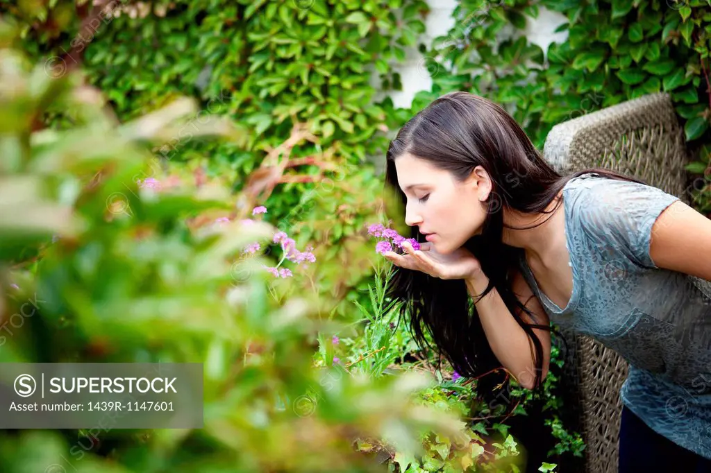 Young woman smelling flower in garden