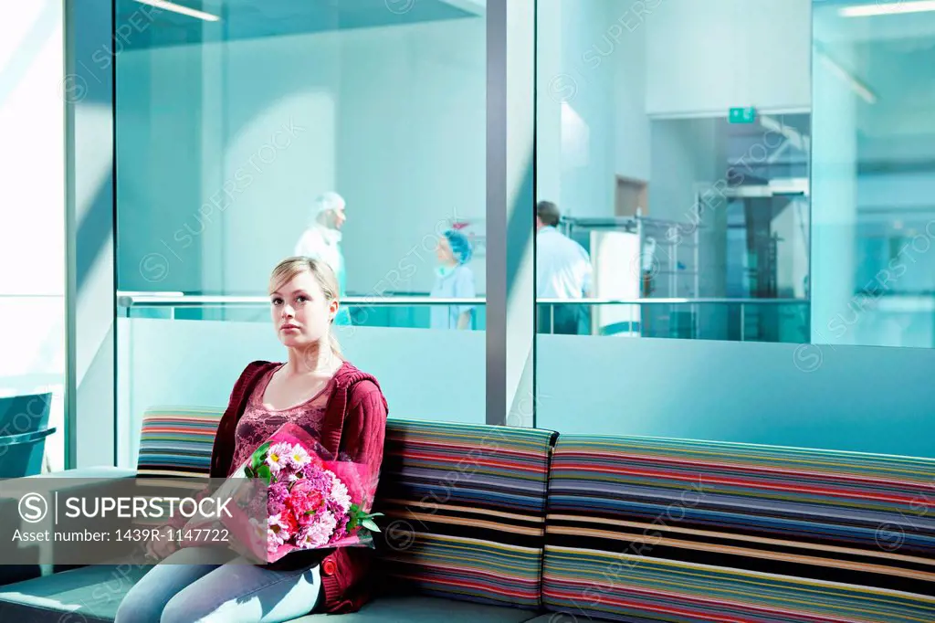 Woman in hospital waiting room with bouquet
