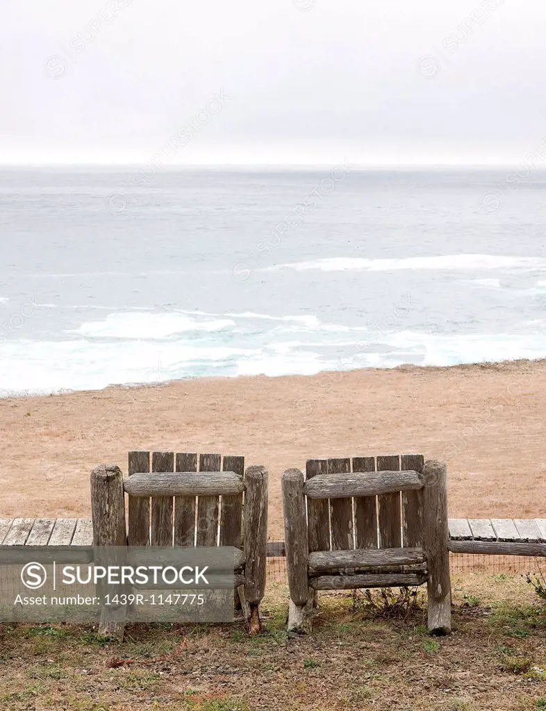 Two empty wooden chairs on beach