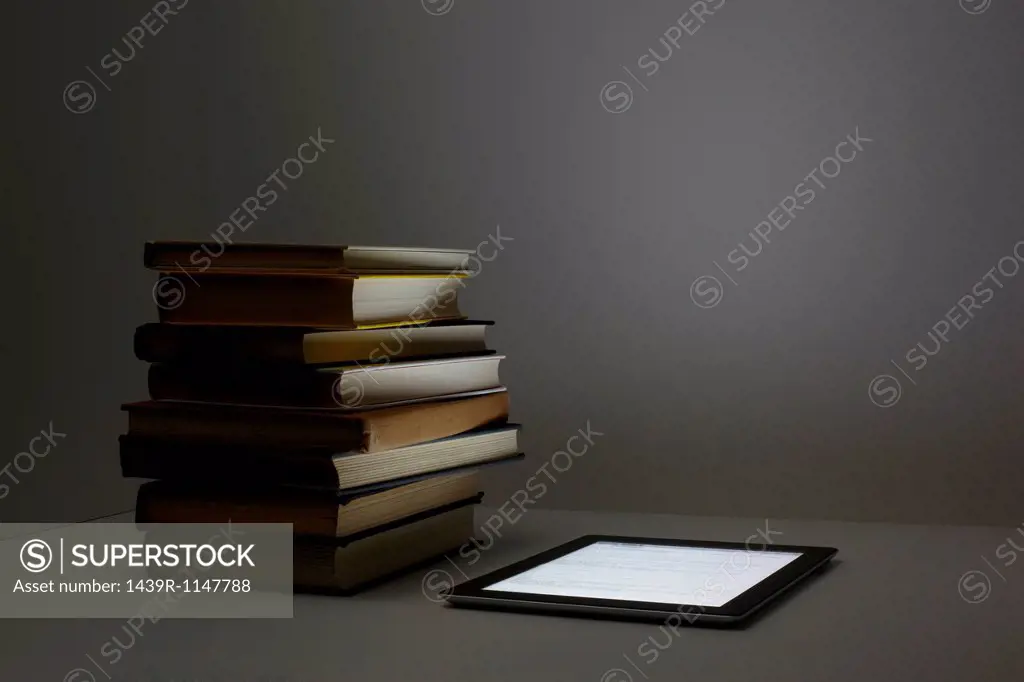 Stack of books with digital tablet