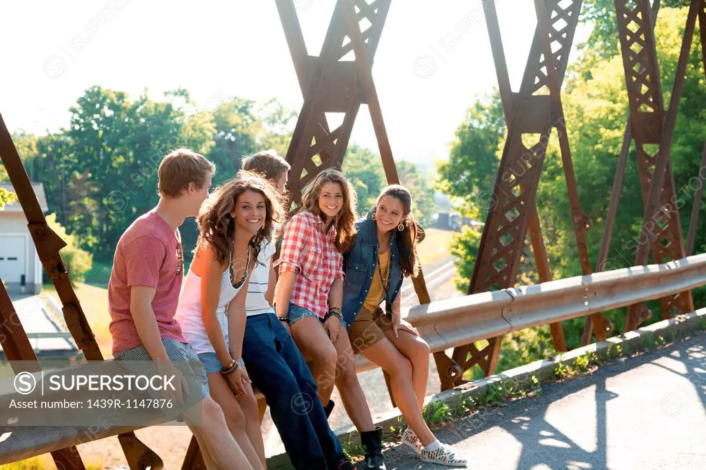 Group of friends sitting on bridge