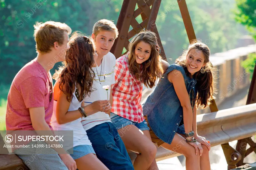 Group of friends sitting on bridge