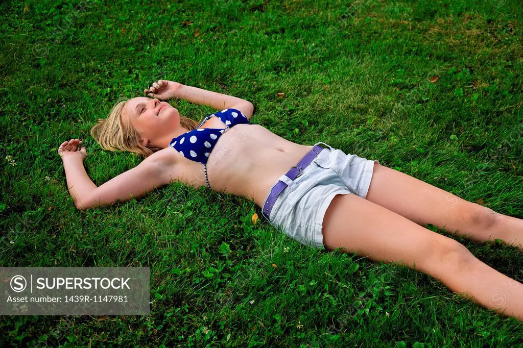 Girl lying on grass, high angle