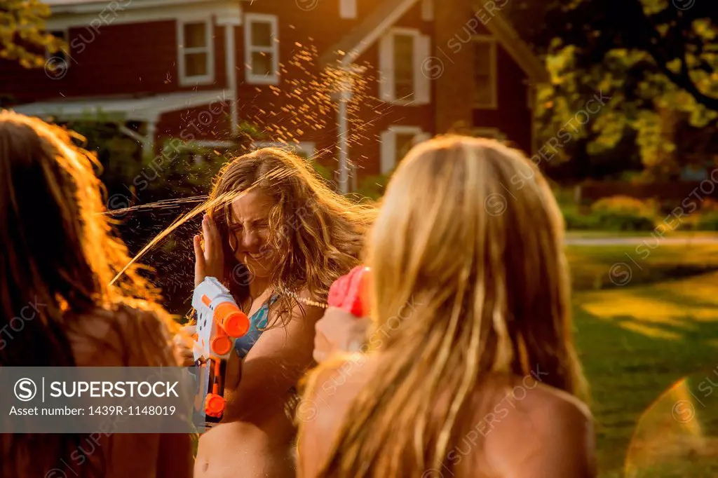 Girls having water fight with water pistols