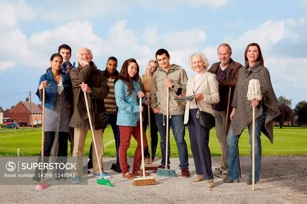 Group of people standing with brooms and mop