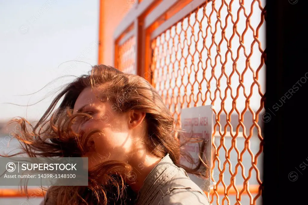 Young woman on a ferry, wind blowing hair
