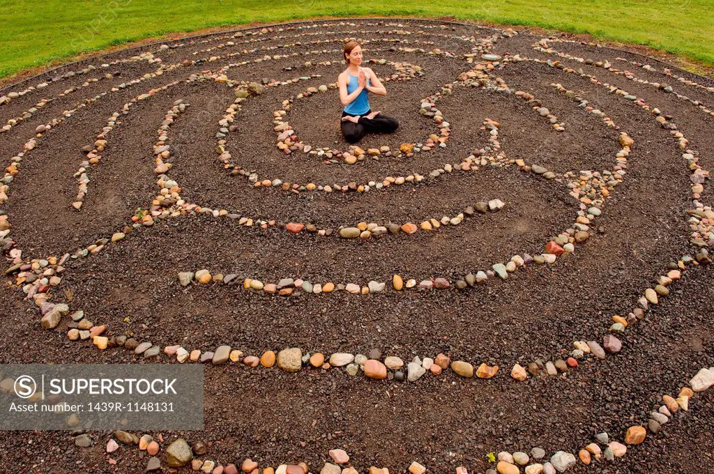 Woman meditating in stone labyrinth