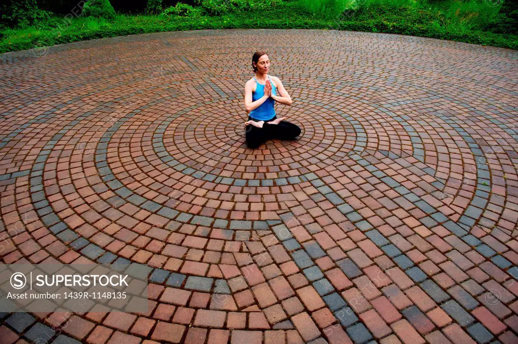 Woman meditating in paving stone circles