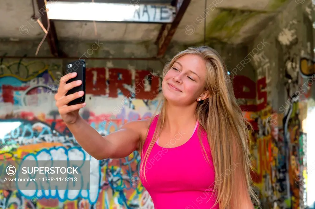 Teenage girl taking a picture of herself on smartphone