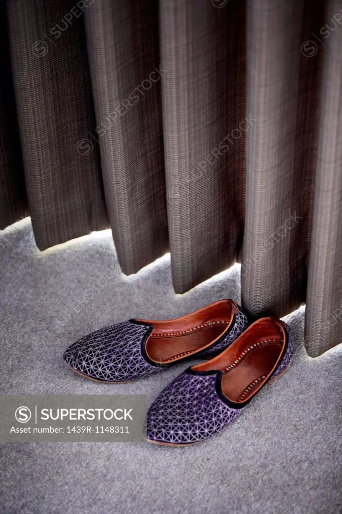 Slippers by a curtain
