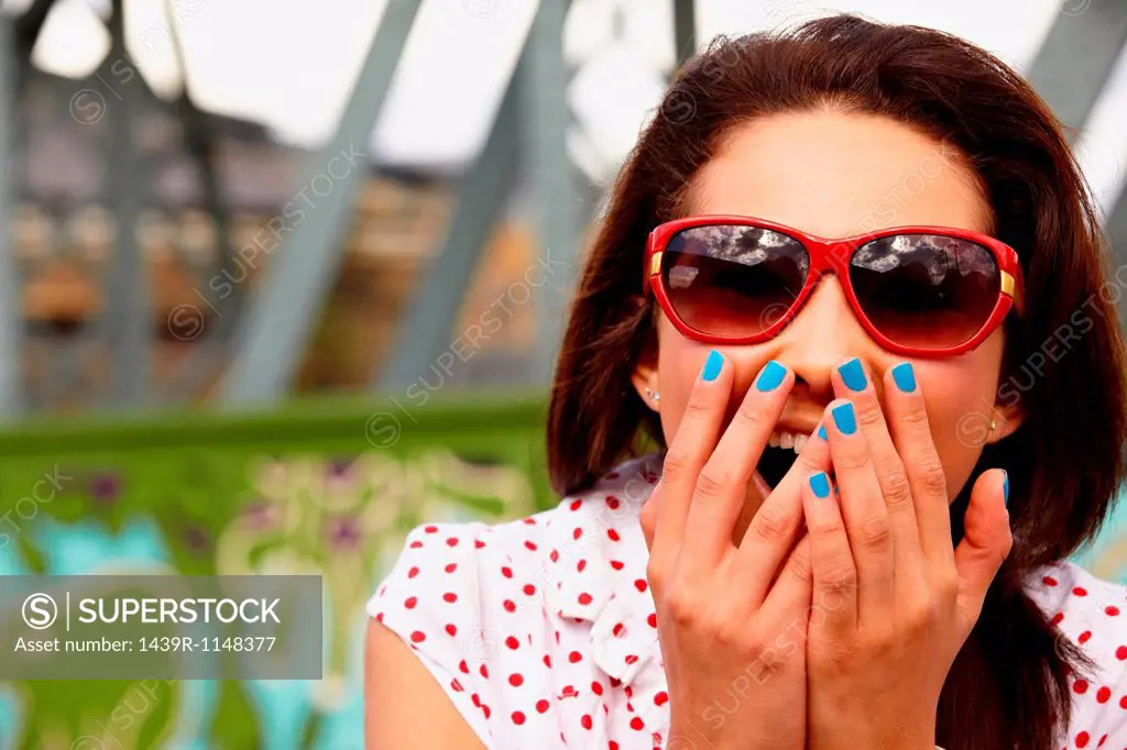 Teenage girl in sunglasses, looking shocked
