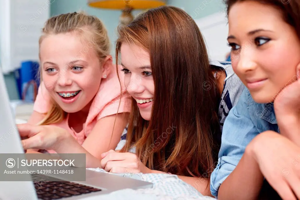 Teenage girls looking at laptop