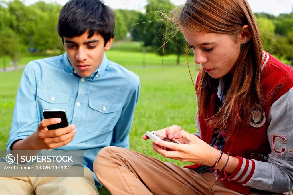 Teenage boy and girl using smartphones