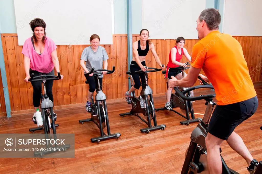 Male instructor and female spinning class