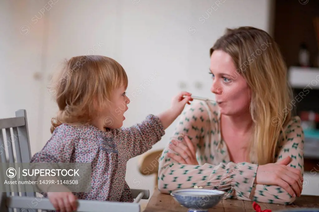 Daughter spoon feeding mother
