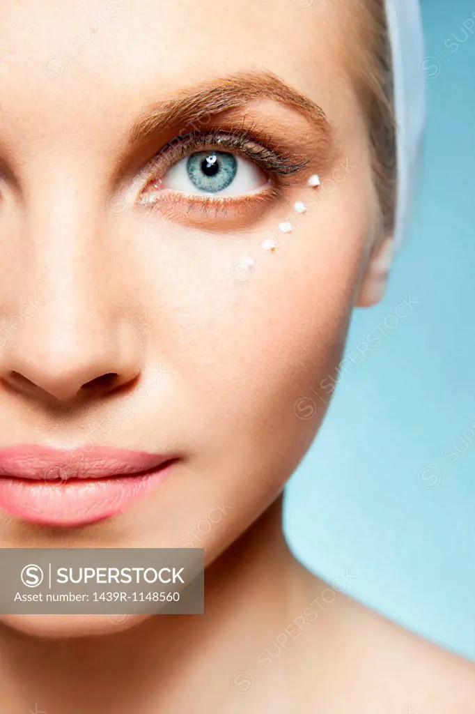 Woman with eye cream around eye