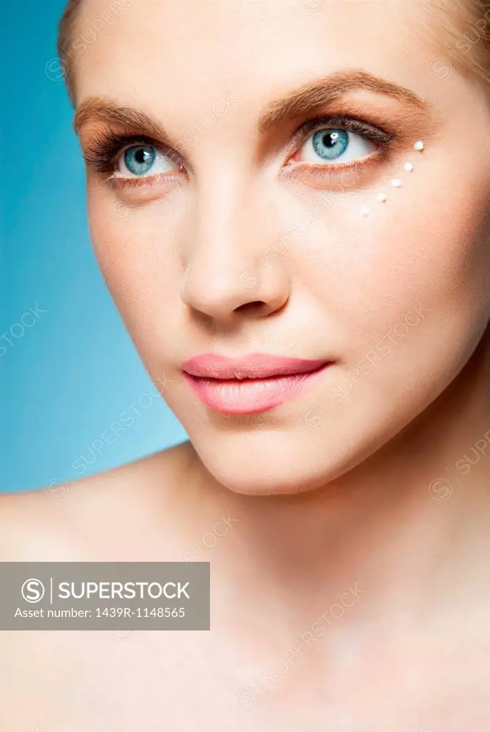 Woman with eye cream around eye